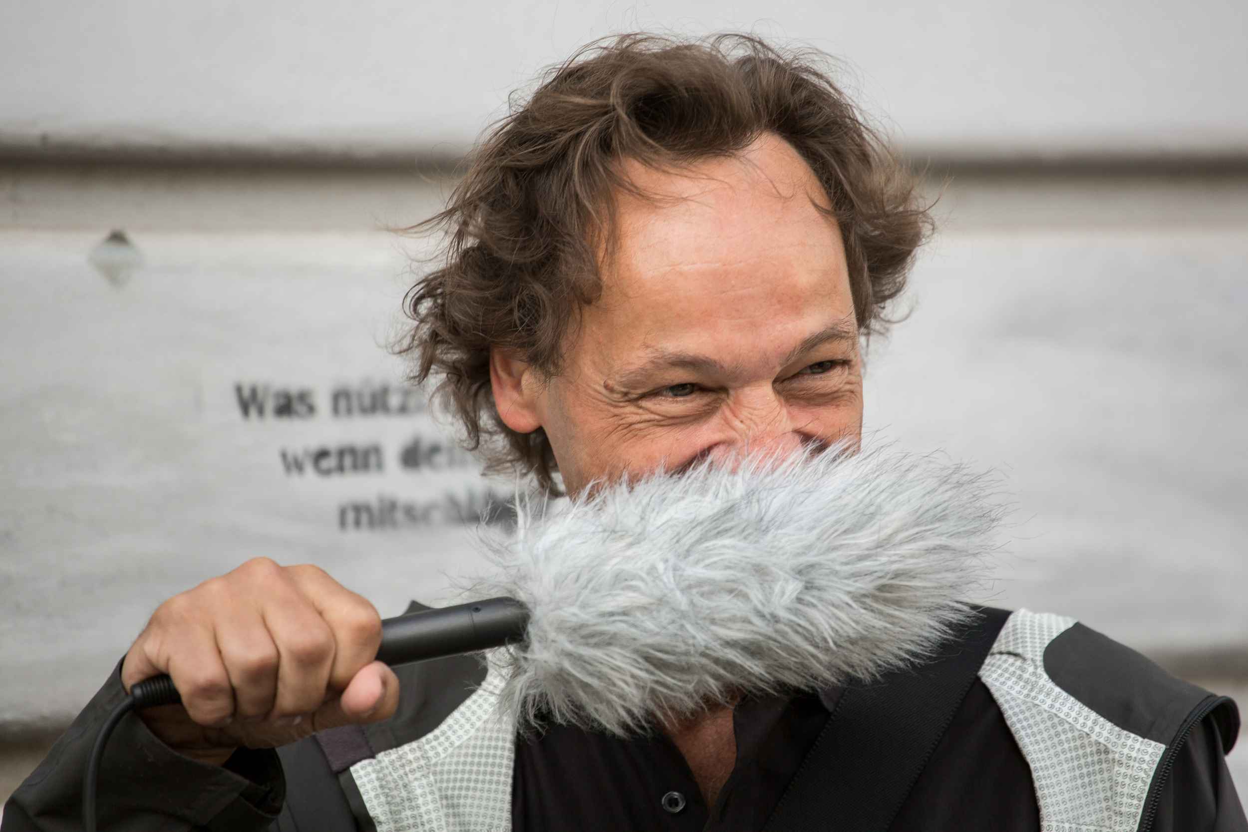 Bertram Weisshaar trägt das Aufnahmegerät als Schnurbart.